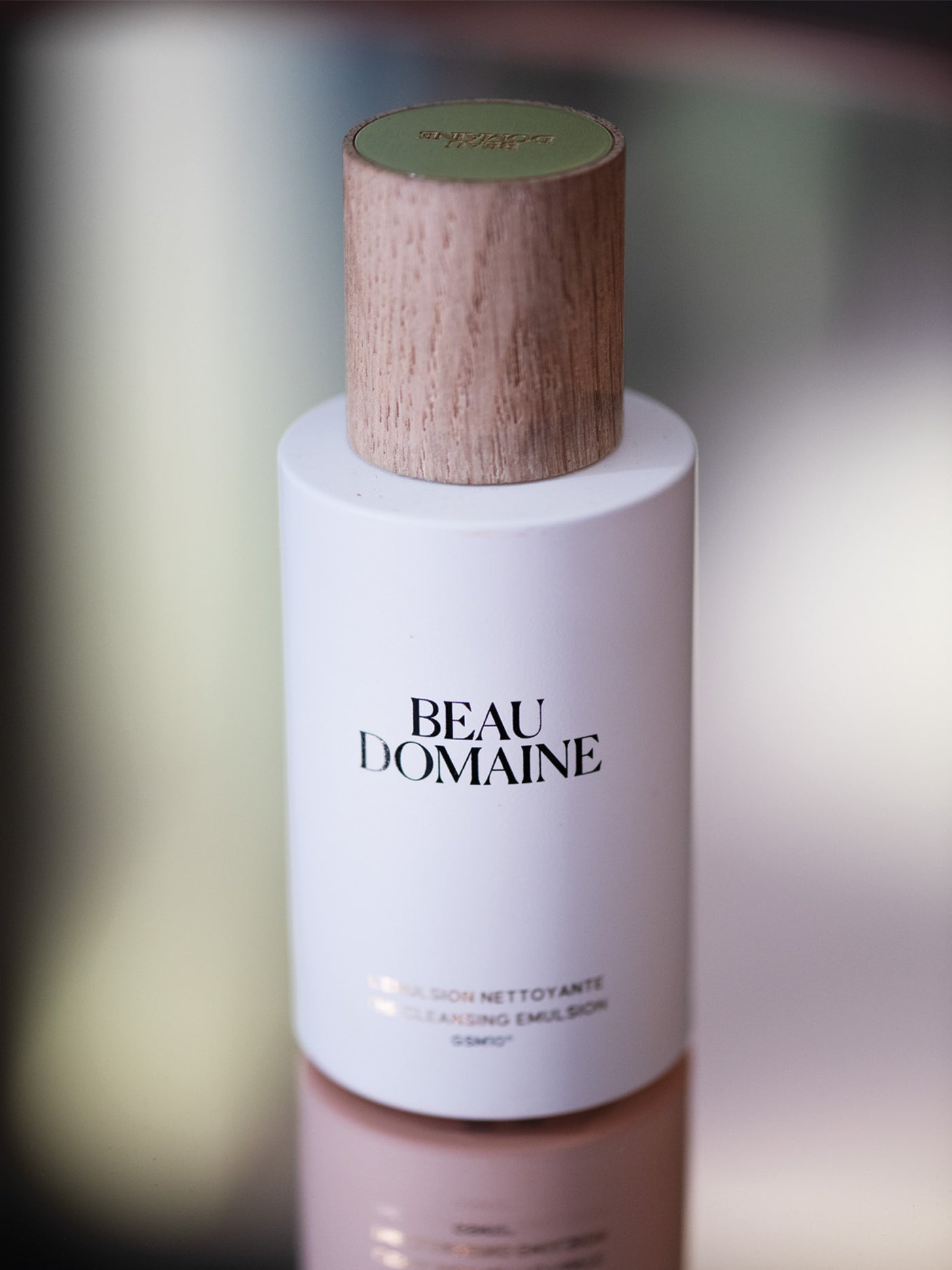 Beau Domaine Hautpflege-Flasche mit Holzdeckel auf einem unscharfen Hintergrund.